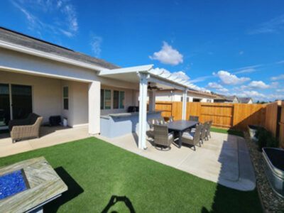 A backyard with a table and chairs and a fire pit.