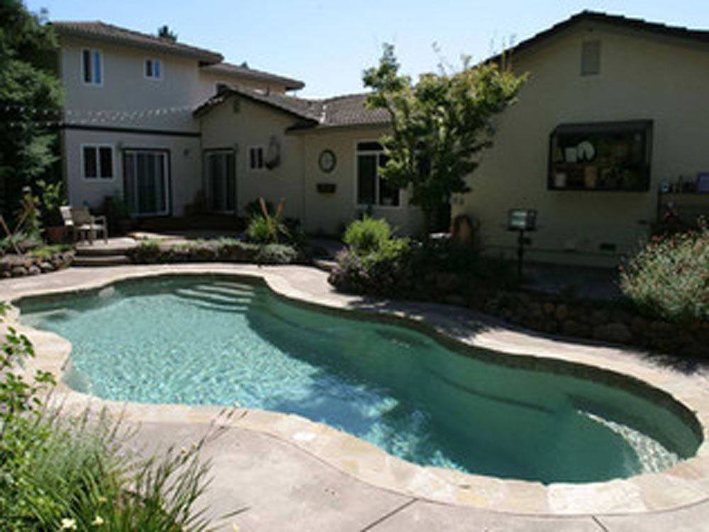 A large swimming pool in the backyard of a house