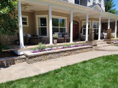 A house with a large porch and a walkway leading to it.