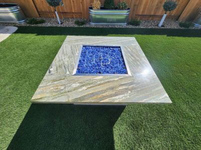 A fire pit is sitting on top of a lush green lawn.
