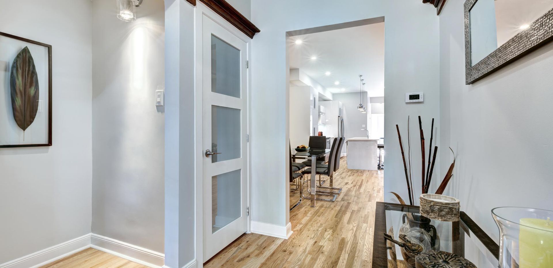 A hallway in a house with hardwood floors and a table.