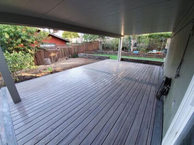 A large wooden deck with a covered patio in the backyard.