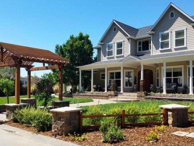 A large house with a large porch and a wooden fence