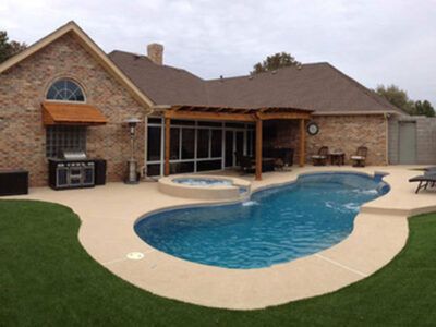 A house with a large swimming pool in front of it