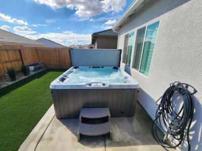 A hot tub is sitting in the backyard of a house.