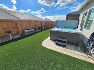 A hot tub is sitting in the backyard of a house.