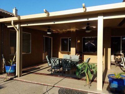 A patio with a table and chairs and a ceiling fan