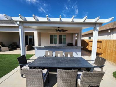 A patio with a table and chairs under a pergola.