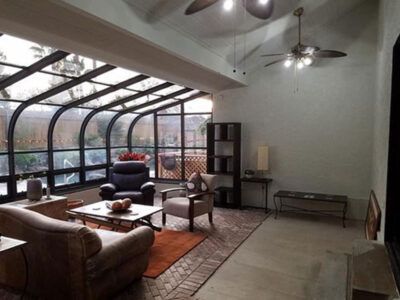 A living room with a lot of furniture and a ceiling fan.