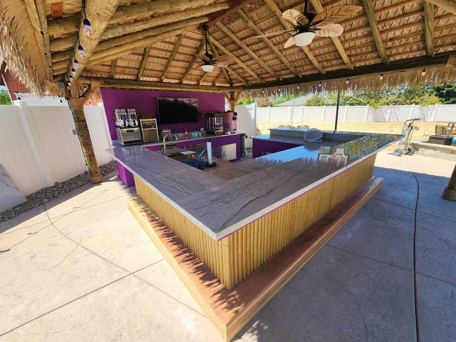 A large wooden bar under a thatched roof.