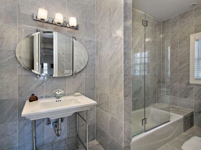 A bathroom with a sink , mirror , tub and shower.