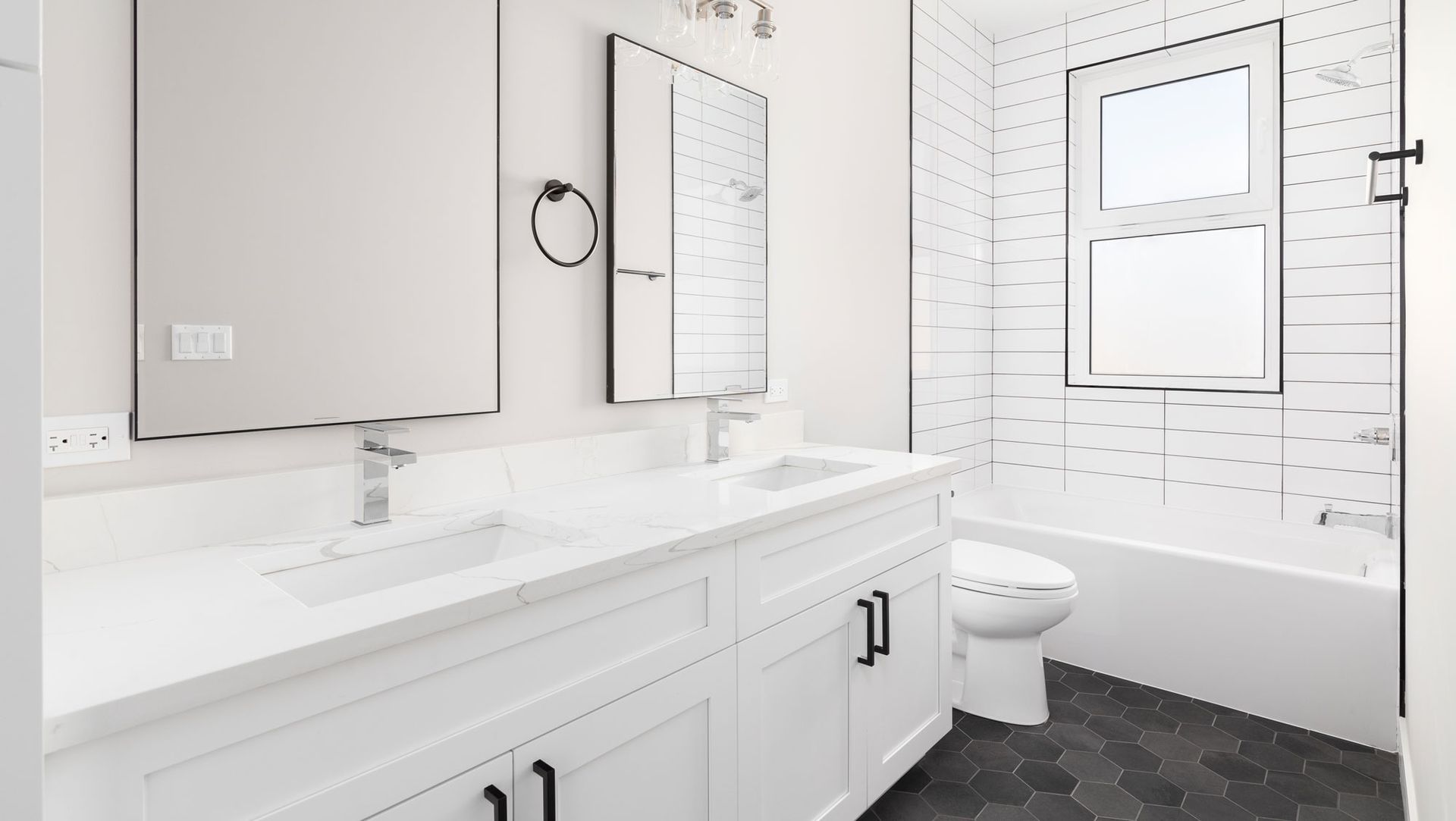 A bathroom with two sinks , a toilet , and a bathtub.