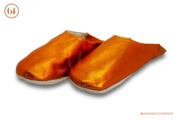 Une paire de chaussons orange avec le numéro 64 en bas