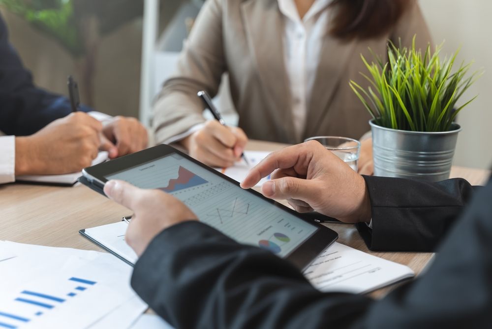 Business professionals collaborating on a tablet computer in a modern office setting.