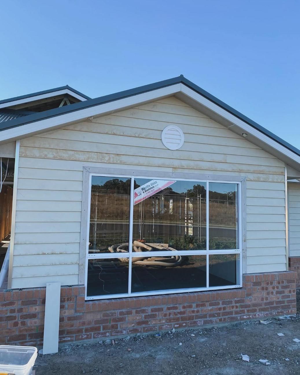 A House With a Lot of Windows and a Clock on the Roof — Trussted Frames & Trusses In Taminda, NSW