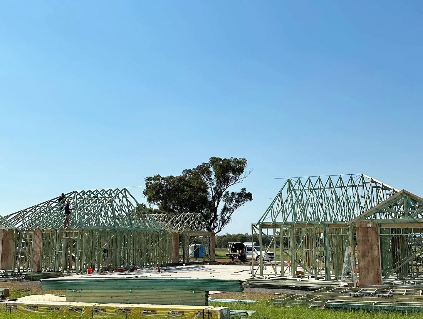 The Roof of a House is Being Built With Wooden Beams — Trussted Frames & Trusses In Taminda, NSW