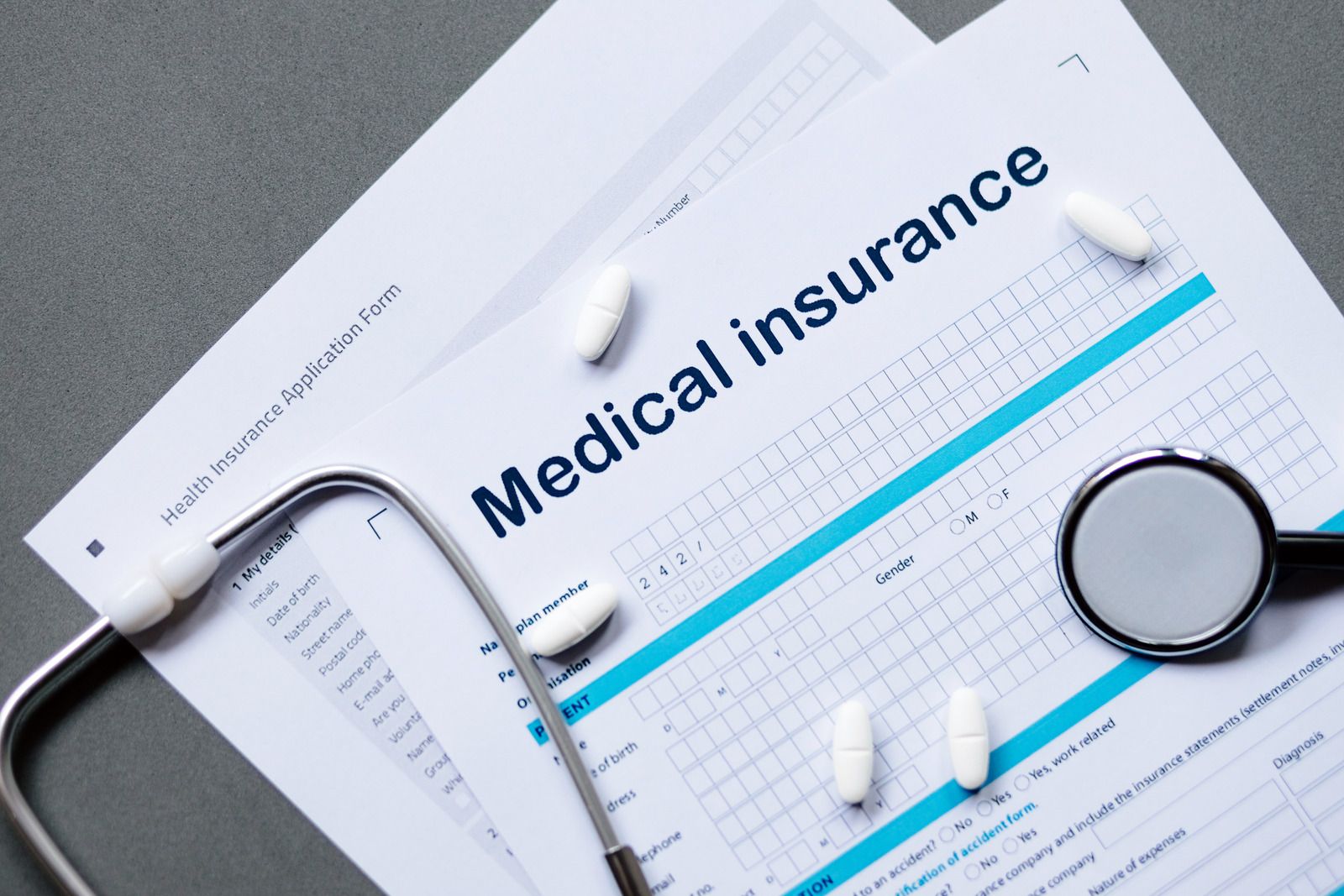 A medical insurance form with a stethoscope and pills on it