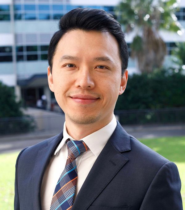 A man in a suit and tie is smiling for the camera.