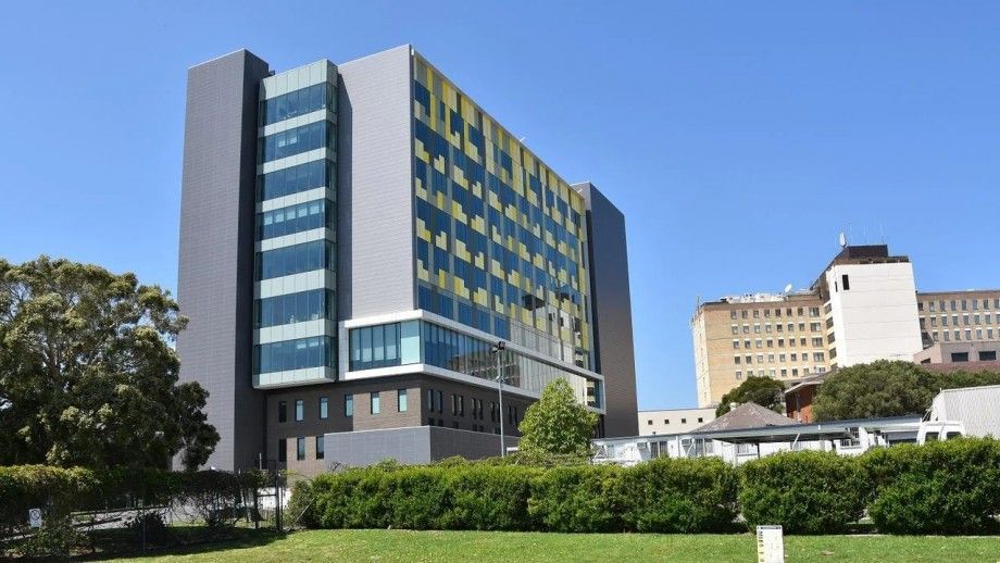 A large building with a lot of windows is sitting on top of a lush green field.