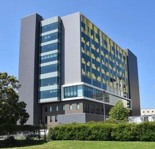 A large building with a lot of windows and a blue sky in the background