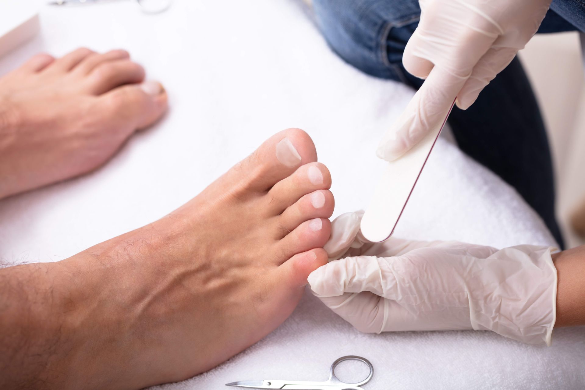 a woman 's feet are in a bowl of water with pink flowers