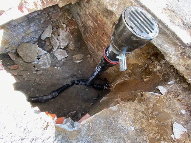 A Drain Pipe Is Being Installed In A Hole In The Ground — Philadelphia, PA — Edward Hughes & Son