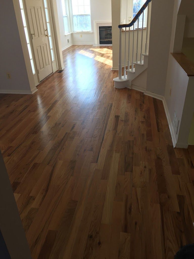 A living room with hardwood floors and stairs in a house.