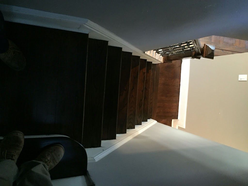 A person is standing on a set of wooden stairs