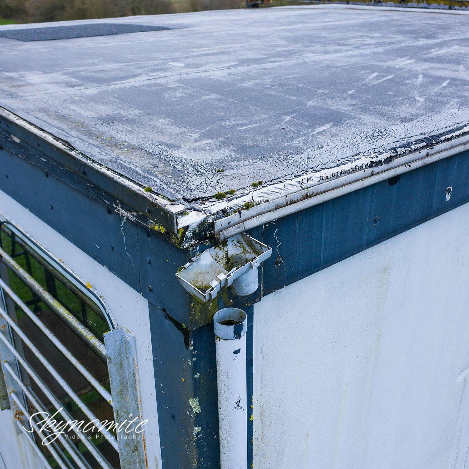 An aerial inspection picture of a dislodged gutter on a first floor portacabin roof