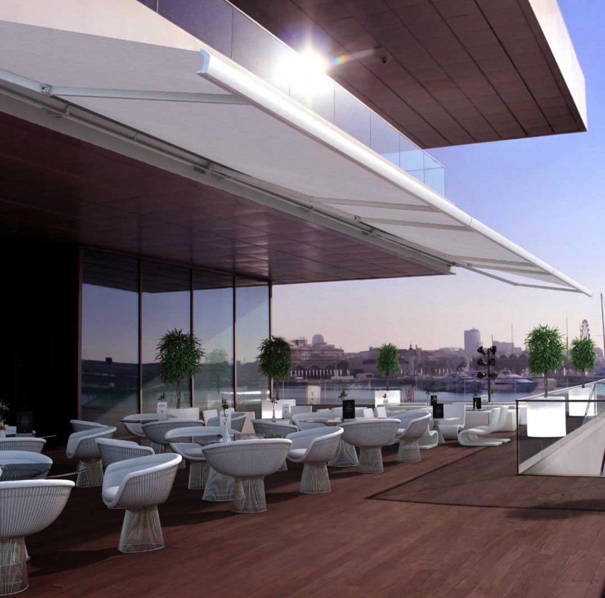 Un patio con tavoli e sedie sotto una tenda da sole che si affaccia su uno specchio d'acqua