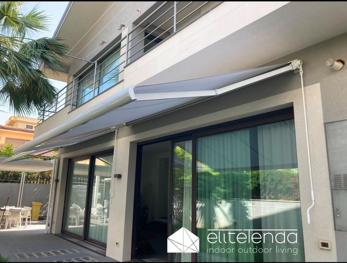 Una grande casa con una tenda bianca su un lato.