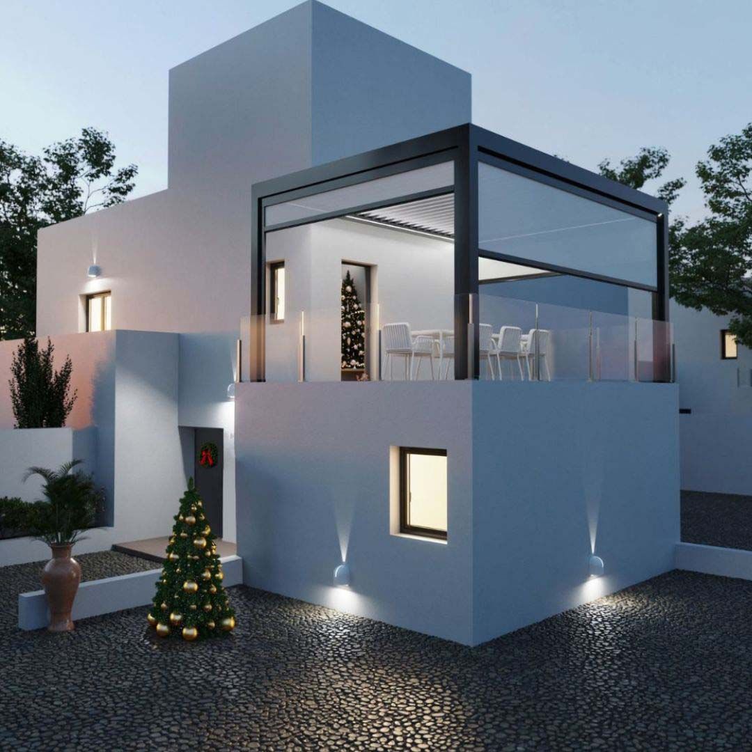 Una casa bianca con un albero di Natale davanti