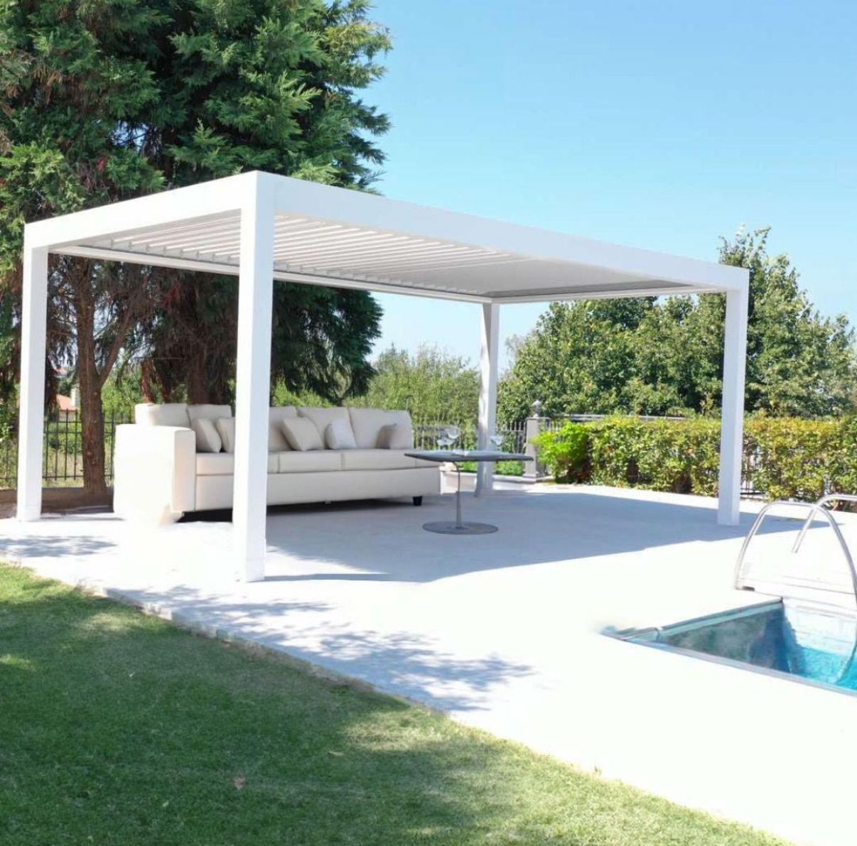 Un pergolato bianco con un divano sotto accanto a una piscina