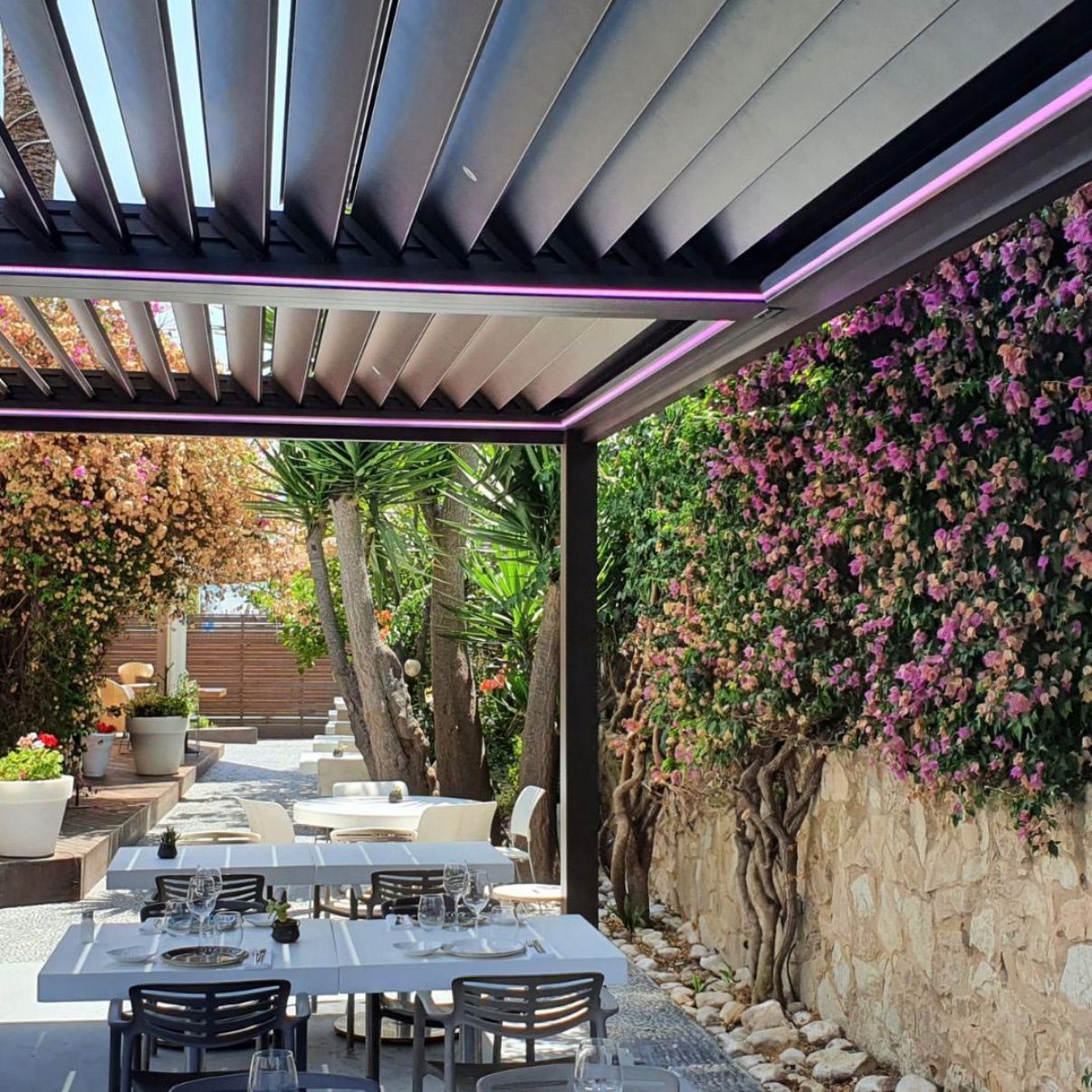 Un ristorante con tavoli e sedie sotto un pergolato