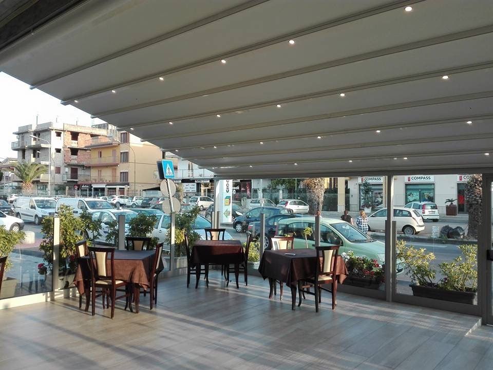 Un ristorante con tavoli e sedie sotto una tenda da sole