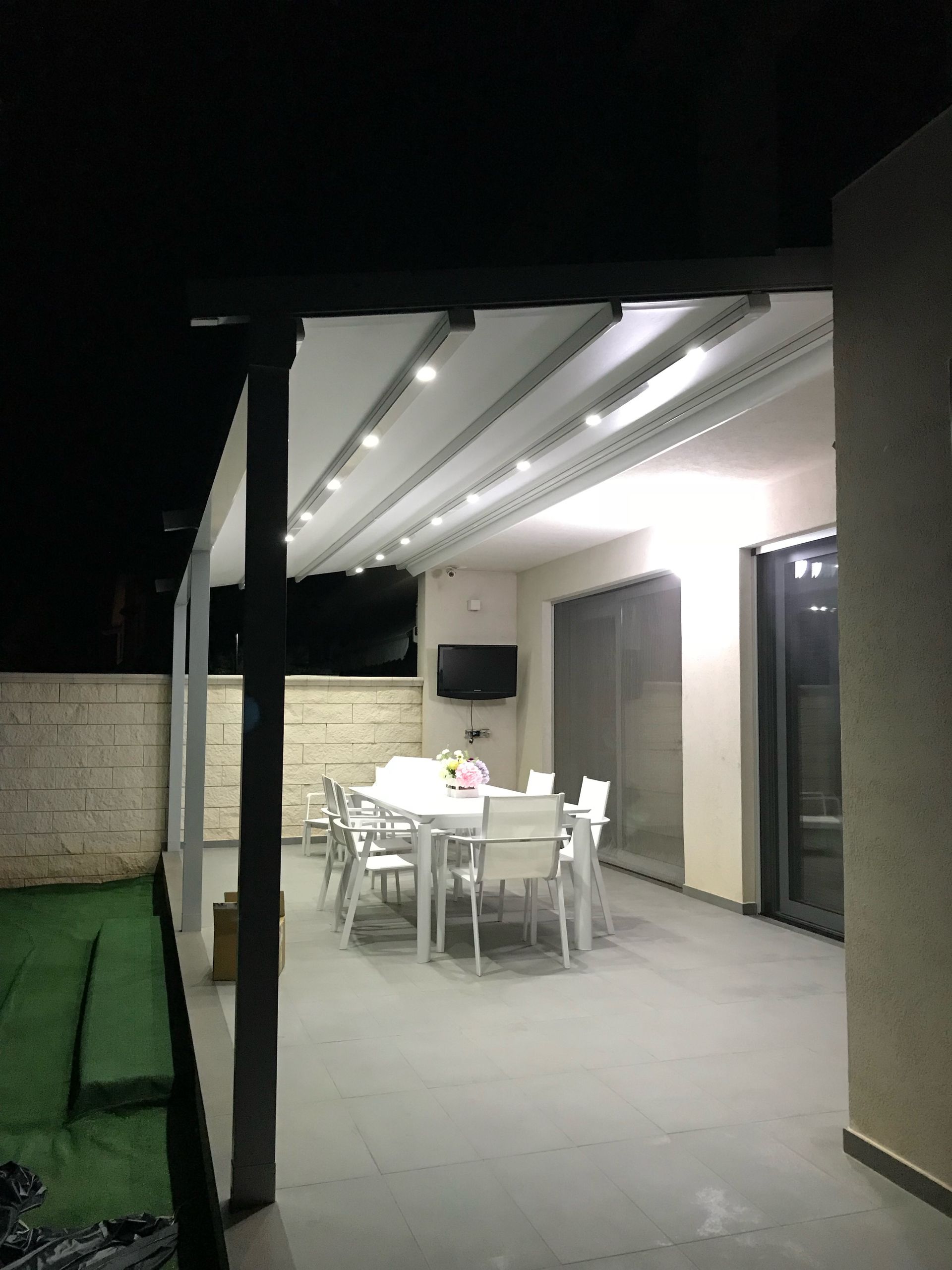 Di notte nel patio c'è un tavolo e delle sedie.