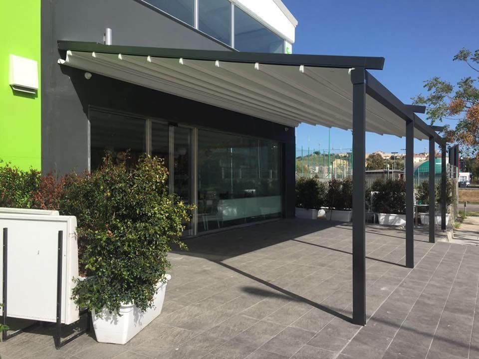 Un patio con una tettoia sopra di fronte a un edificio