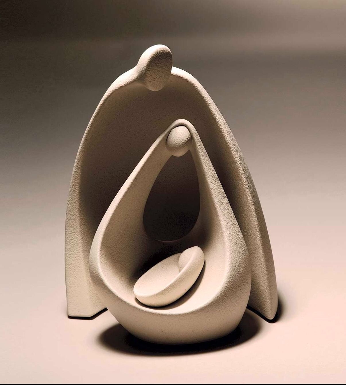 Una statua di una donna che tiene in braccio un bambino su un tavolo