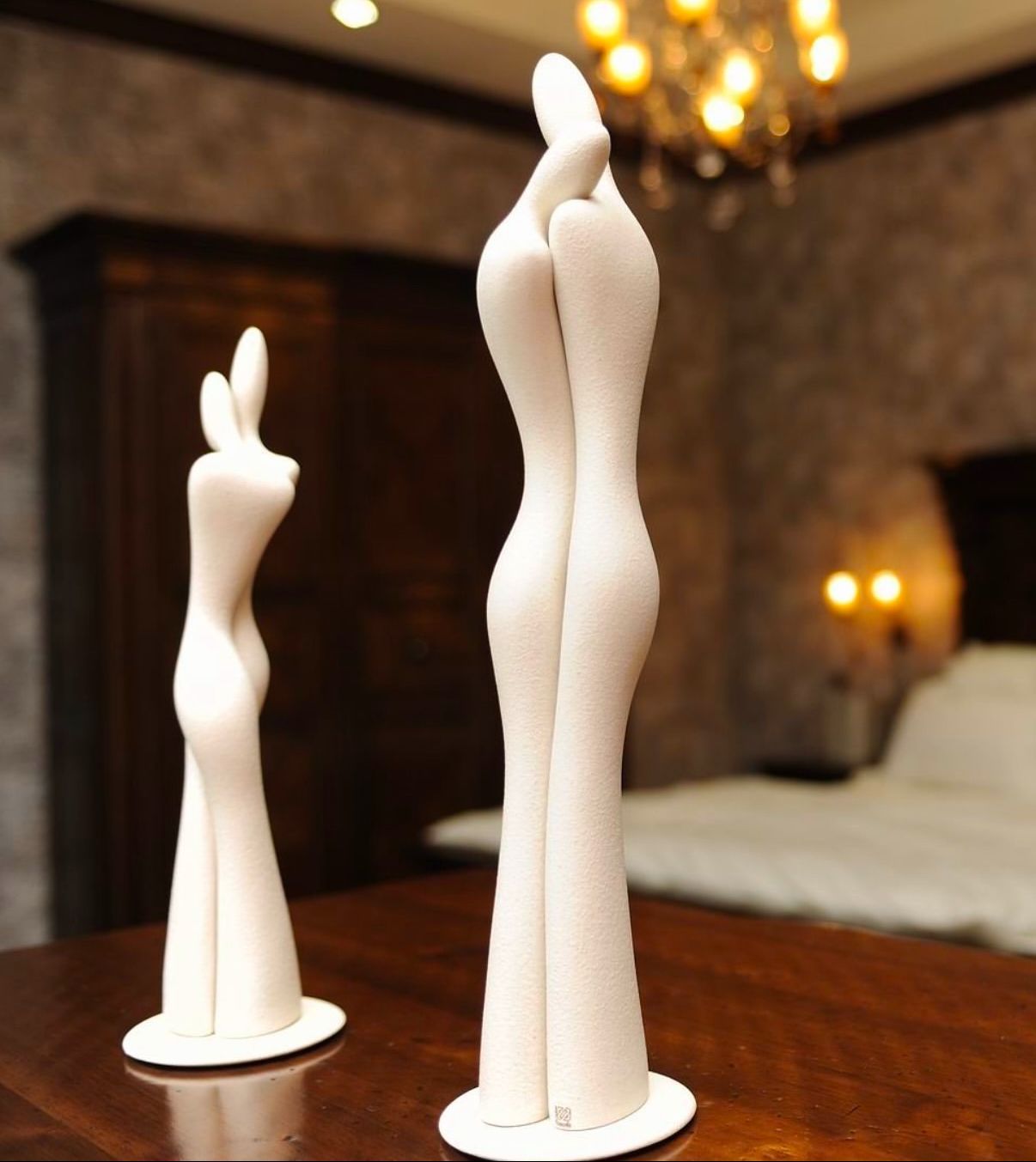 Due statue bianche di un uomo e una donna in piedi uno accanto all'altro su un tavolo