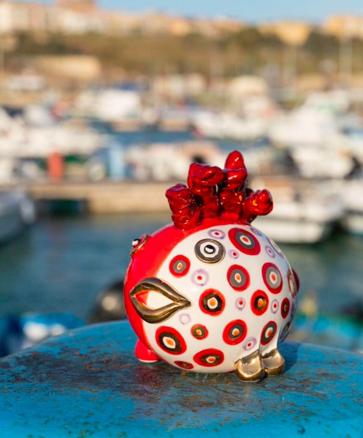 Un salvadanaio rosso e bianco è appoggiato su una superficie blu.