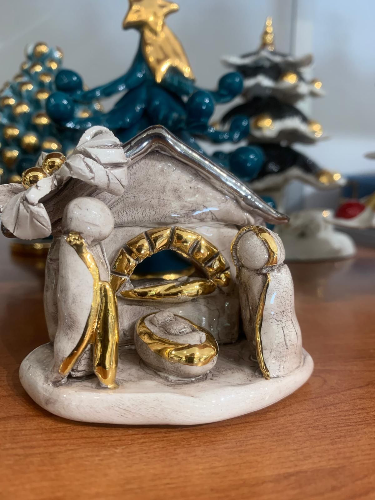 Un presepe in ceramica è appoggiato su un tavolo di legno.