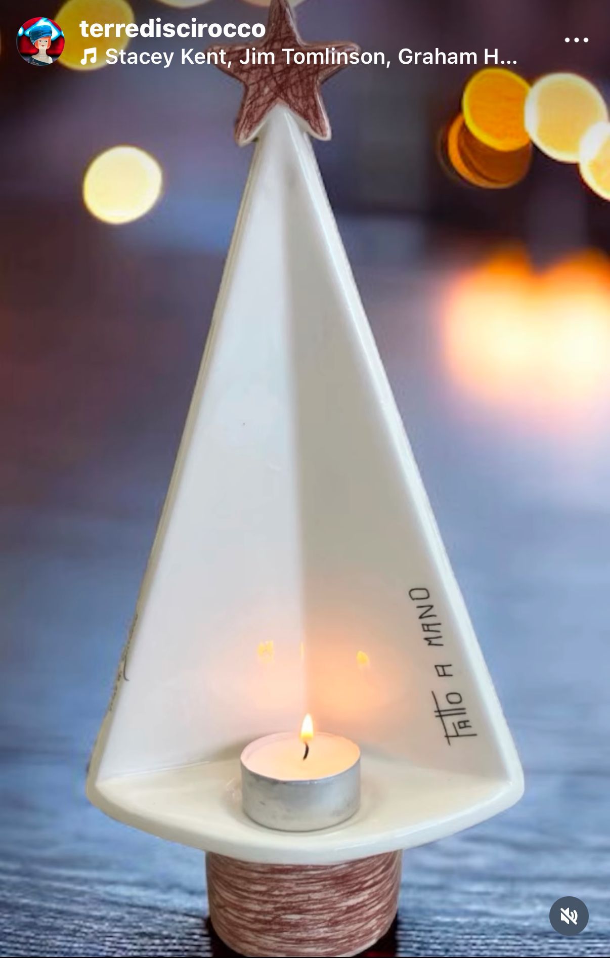 Un albero di Natale in ceramica bianca con una candela al suo interno.