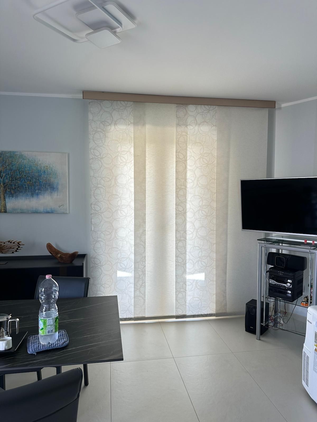 Un soggiorno con un tavolo e una tv a schermo piatto