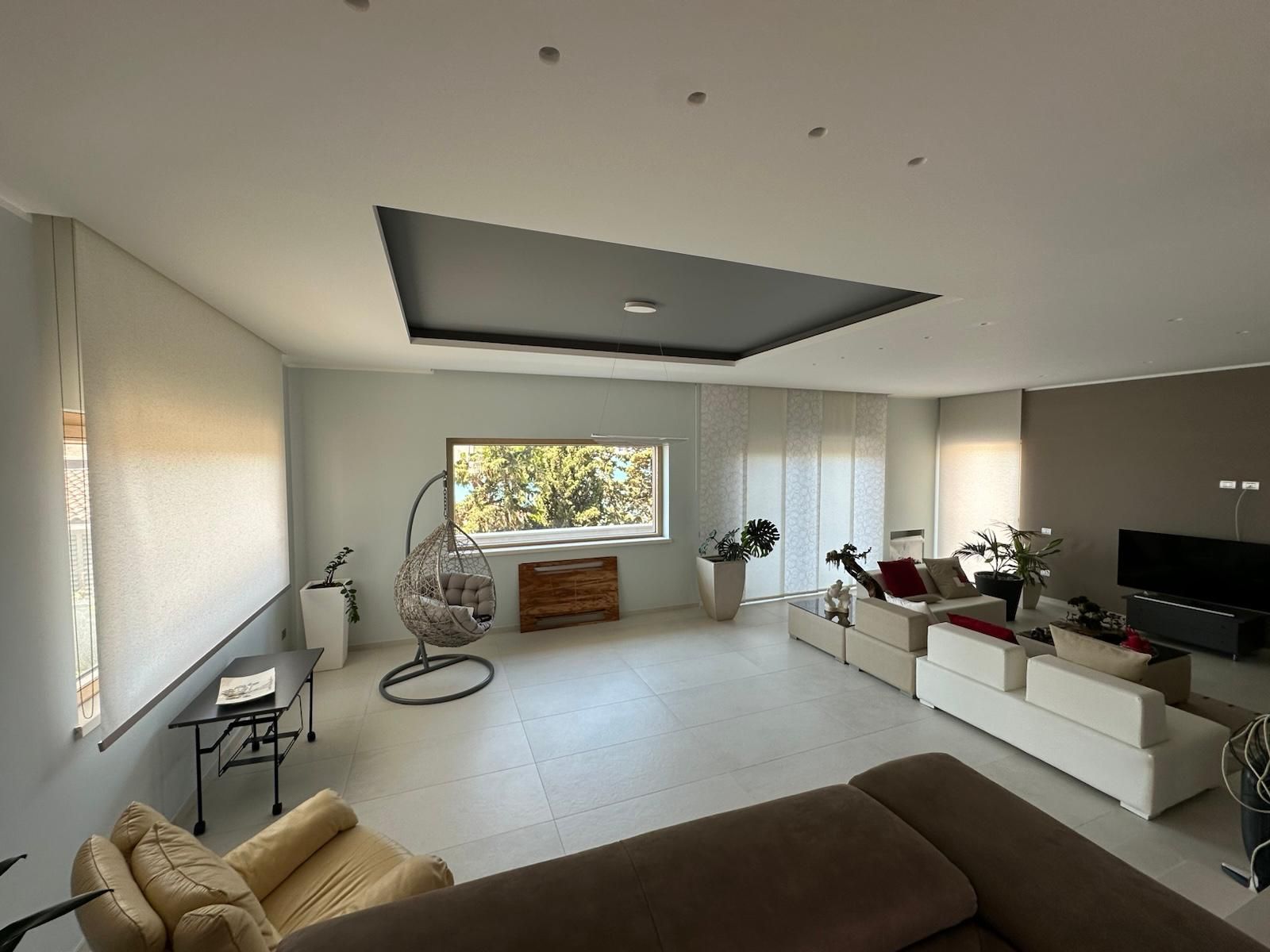 Un soggiorno pieno di mobili e una grande finestra