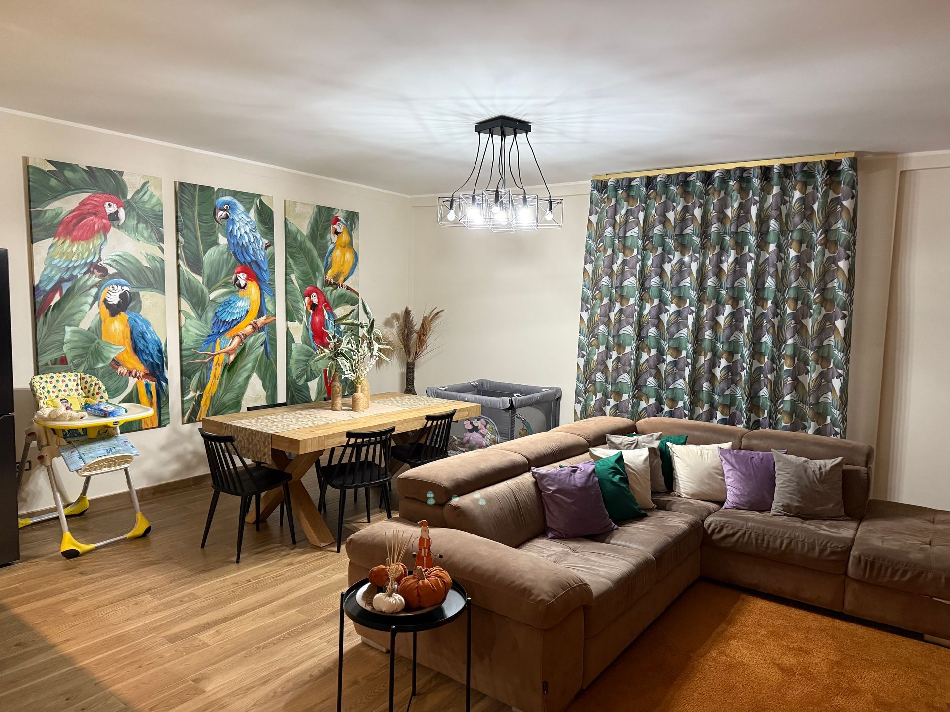 Un soggiorno con divano, tavolo, sedie e quadri alle pareti.