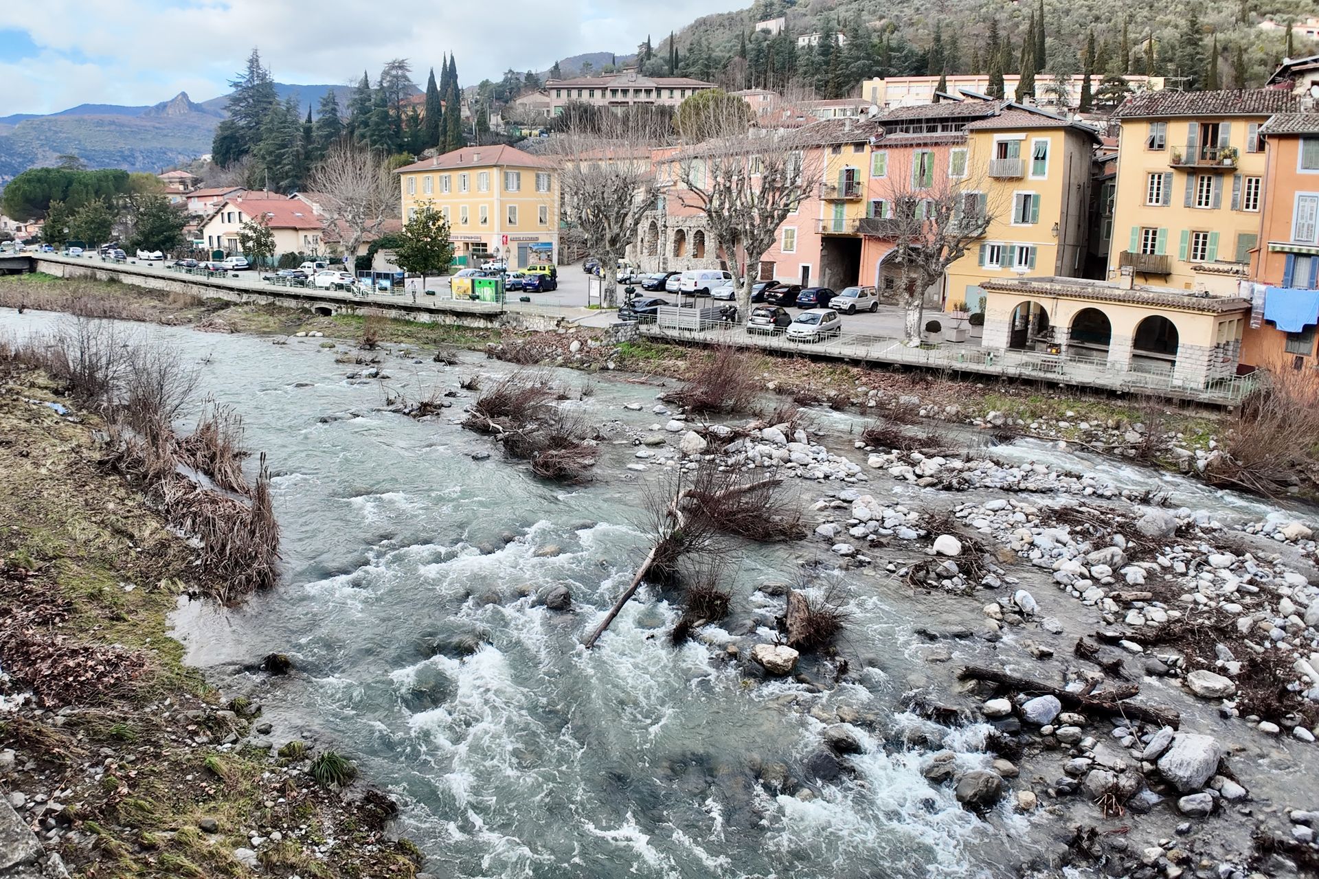 Een rivier stroomt door een stad met kleurrijke gebouwen aan de oever.