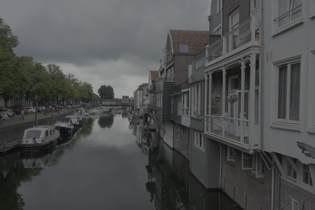 Een rivier omringd door gebouwen en boten op een bewolkte dag.