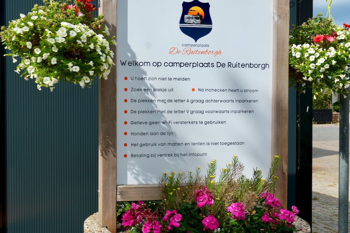 Welkomsbord Welkomstbord voor camperplaats De Ruitenborgh, met bloemen aan weerszijden.