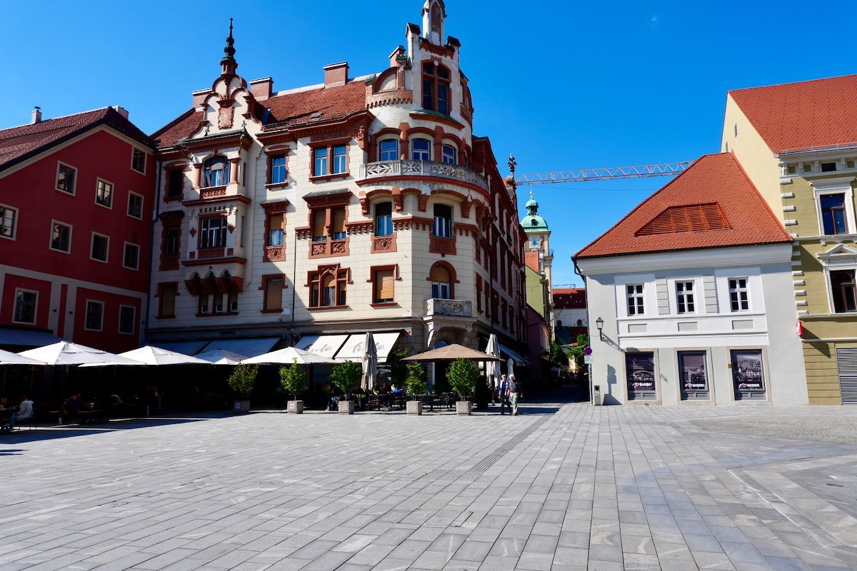 Een stadsplein met gebouwen en parasols op een zonnige dag