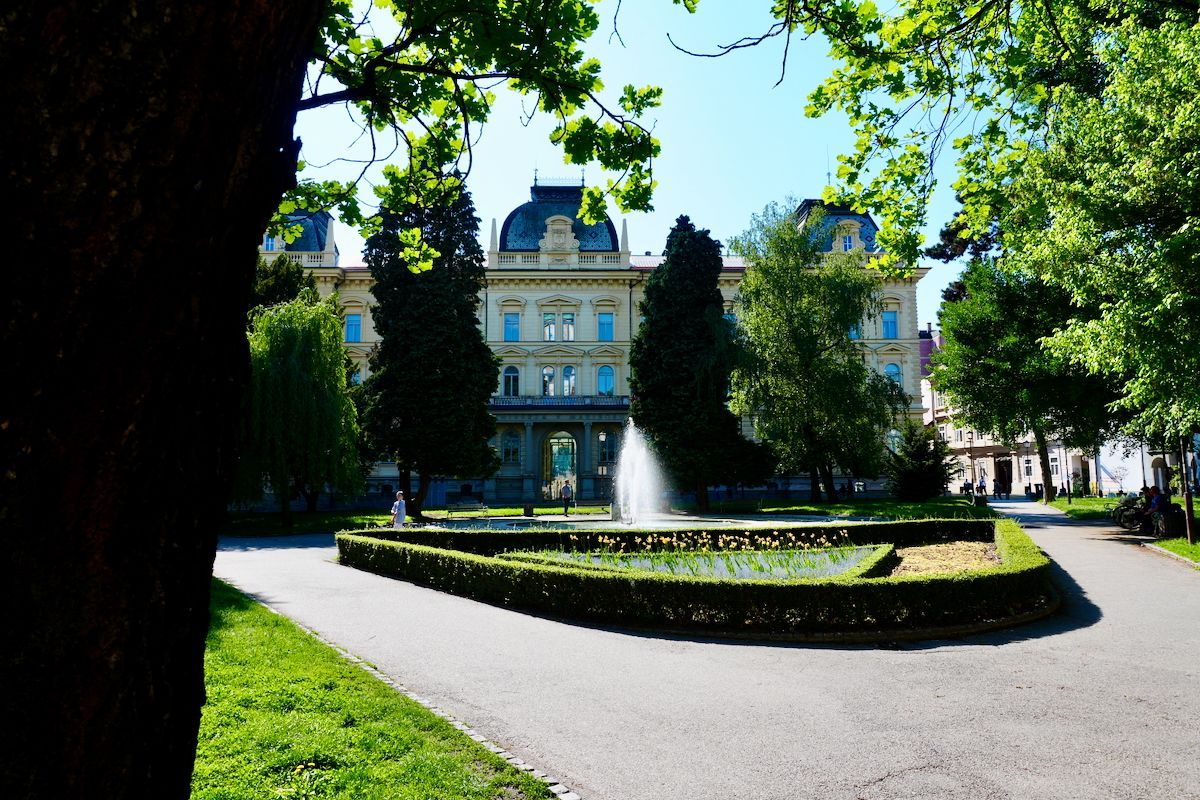 University of Maribor Een groot gebouw met een fontein ervoor
